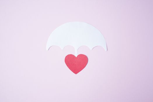 Red paper heart shape under white paper umbrella as life, health insurance concept. Assurance. insurance life symbol