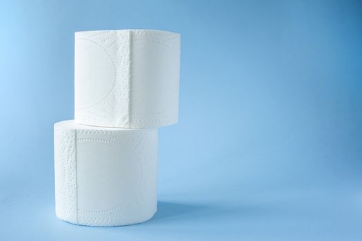 two Toilet paper roll on a blue background top view. Toilet paper purchase due to kronavirus concept. Personal hygiene and stopping the spread of the virus. Cleanliness, Hygiene, Sterility copy space