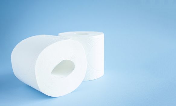 two Toilet paper roll on a blue background top view. Toilet paper purchase due to kronavirus concept. Personal hygiene and stopping the spread of the virus. Cleanliness, Hygiene, Sterility copy space