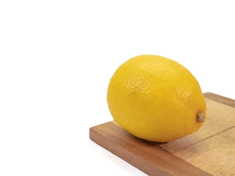 The close up of  fresh yellow lemon organic food on small wooden board on white background.