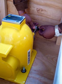 The worker spins the padlock code to unlock the mechanical shutter of the new container of the nuclear base instrument