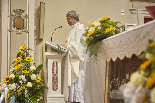 Priest celebrates the liturgy in a Catholic church in Italy