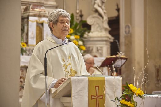 Priest celebrates the liturgy in a Catholic church in Italy