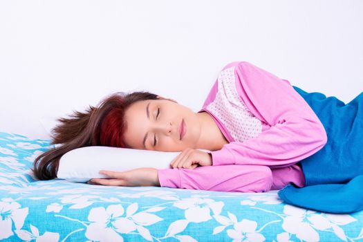 Beautiful young girl in pajamas calmly sleeping in her bed. Beauty sleep concept.