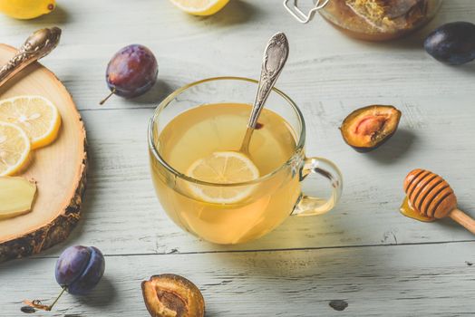 Cup of tea with lemon, honey and ginger over wooden surface