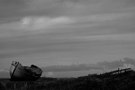 Black and white image of an abandoned wooden fishing boat on the Welsh island of Anglesey