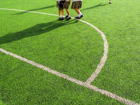 Children play on the artificial turf of the school