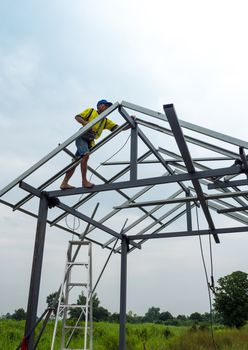 CHONBURI, THAILAND - Oct 12, 2016 Unidentified man walk and work on the steel frame of the house is under construction without protective equipment.