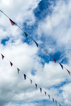 Multi-color triangle flag hanging on the rope and blue sky