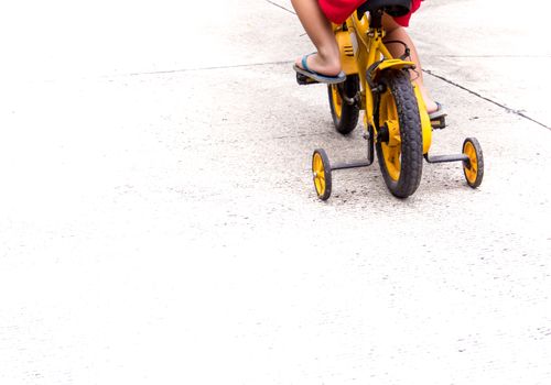 Children with slippers cycling bike with training wheels to prevent falls