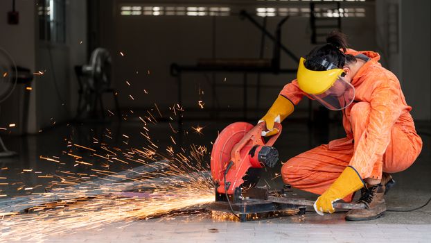 Industrial worker cutting the steel to the size that the customer wants. For the real estate project received. Metal grinding on steel spare part in workshop.