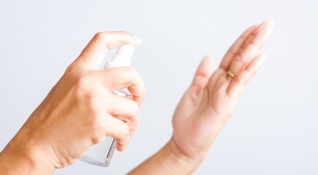 Closeup Hand Asian young woman applying spray pump dispenser sanitizer alcohol on hand wash cleaning, hygiene prevention COVID-19 or coronavirus protection concept, isolated on white background