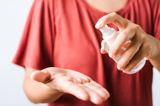 Closeup Hand Asian young woman applying spray pump dispenser sanitizer alcohol on hand wash cleaning, hygiene prevention COVID-19 or coronavirus protection concept, isolated on white background