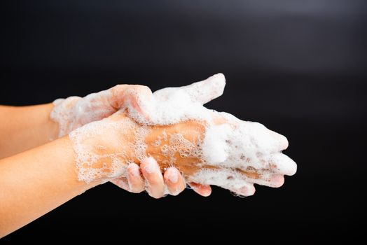 Closeup body care Asian young woman washing hands with soap have foam, hygiene prevention COVID-19 or coronavirus protection concept, isolated on black background