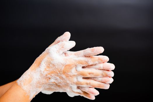 Closeup body care Asian young woman washing hands with soap have foam, hygiene prevention COVID-19 or coronavirus protection concept, isolated on black background