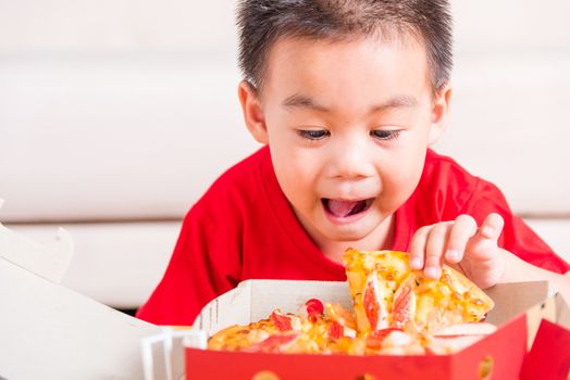 Hot Homemade, Vegetarian fast Italian food, Cute Little Child enjoying holding Delivery Pizza pepperoni, cheese many slices in an open cardboard box at home