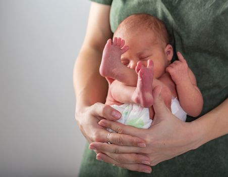 Beautiful new born baby resting on mom's hands.