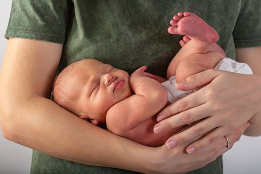 Beautiful new born baby resting on mom's hands.