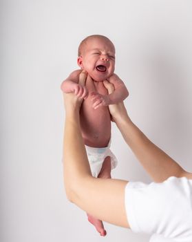 Portrait of a screaming newborn hold at hands, family, healthy birth concept photo, close up.