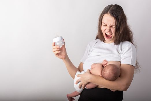 A mother breastfeeds a baby, not a bottle. Natural feeding concept