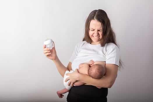 A mother breastfeeds a baby, not a bottle. Natural feeding concept