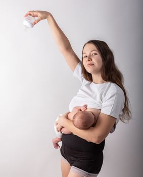 A mother breastfeeds a baby, not a bottle. Natural feeding concept