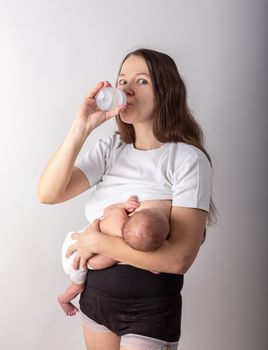 A mother breastfeeds a baby, not a bottle. Natural feeding concept