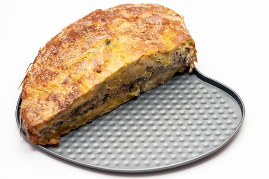 Homemade yeast-free cake on kefir with a filling of canned fish and potatoes, close-up. A hearty dish for a Flexitarian