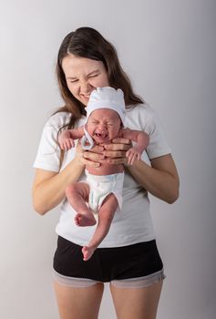 Newborn baby cries in the arms of his mother.