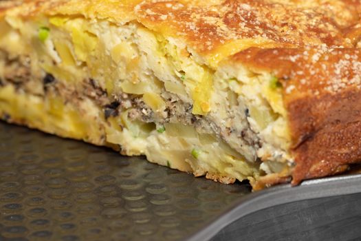 Homemade yeast-free cake on kefir with a filling of canned fish and potatoes, close-up. A hearty dish for a Flexitarian