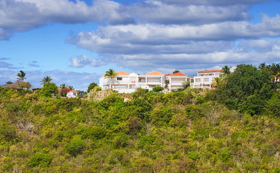 A large mansion on top of a green tropical hill