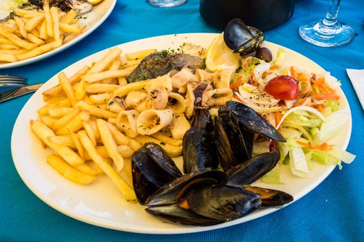 Seafood platter with fries and small vegetables in Malta