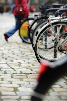 Pparked bicycles with pedestrians in the background with blur effect