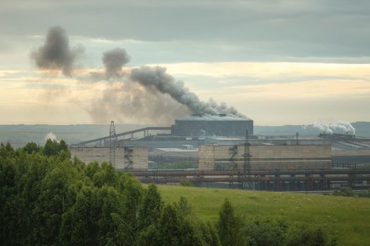 Factory pipe polluting air, smoke from chimneys against sun, environmental problems, ecological theme, industrial scene of accident at factory