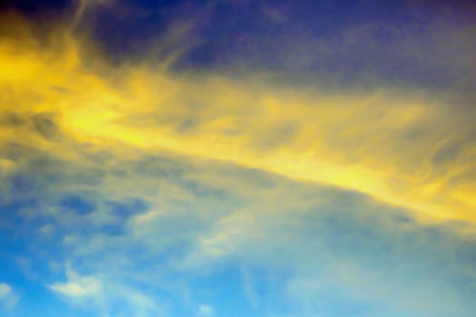 Fluffy yellow clouds in the blue sky