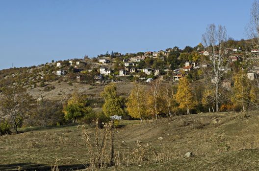 Amazing autumn view of glade, hill, forest with deciduous trees and residential district of the pretty village Zhrebichko, Bratsigovo municipality,  Rhodope mountains, Bulgaria