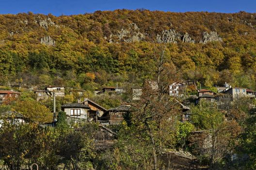 Amazing autumn view of glade, hill, forest with deciduous trees and residential district of the pretty village Zhrebichko, Bratsigovo municipality,  Rhodope mountains, Bulgaria