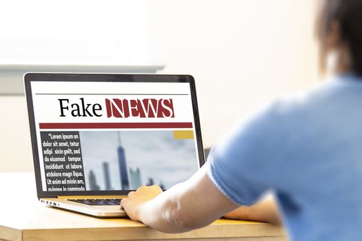 A female reading fake news on a computer laptop