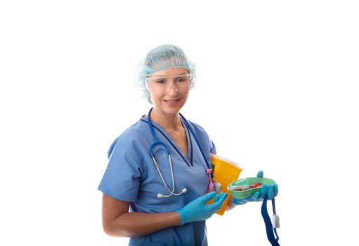 A nurse or pathologist holding blood tubes in a kidney dish, with tourniquet and sharps container