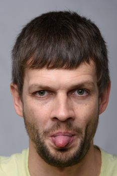 Portrait of a man of European appearance showing tongue, close-up