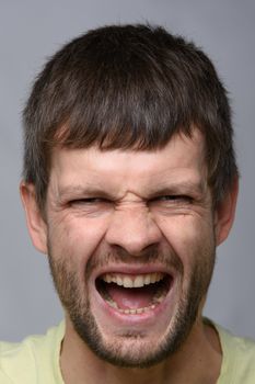 Portrait of a man of European appearance, experiencing severe pain, close-up