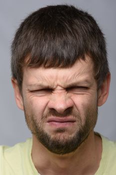 Close-up portrait of a man with an emotion of disgust, European appearance