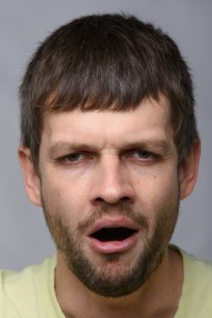 Closeup portrait of a tired yawning man of European appearance