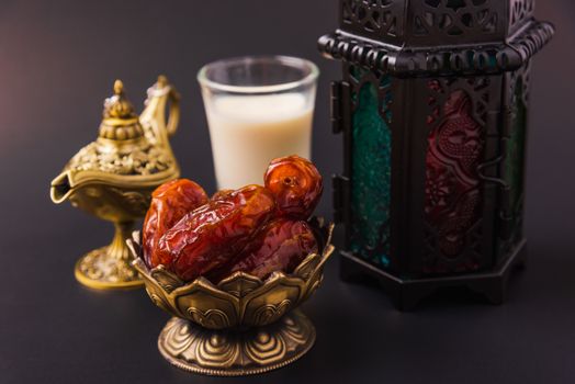 Ramadan Kareem fasting Food Concept, Bronze plate dates, milk, and lantern Aladdin lamp decoration, eid Arabian Muslim religious festival on a black background with copy space for text