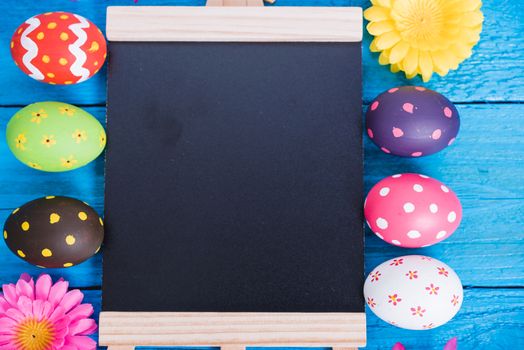 Easter eggs top view on blue wooden background and have board work space board for use