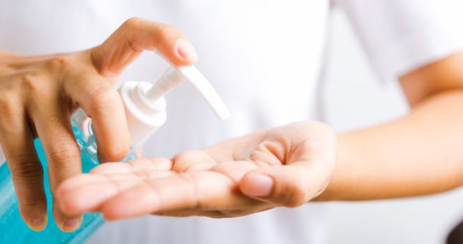 Closeup Hand Asian young woman applying pump dispenser sanitizer alcohol gel on hand wash cleaning, hygiene prevention COVID-19 or coronavirus protection concept, isolated on white background