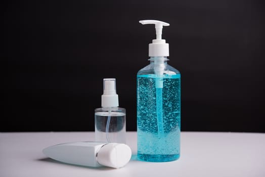 Plastic dispenser sanitizer alcohol gel pump and spray bottle for washing hand hygiene prevention of coronavirus virus studio shot on black background