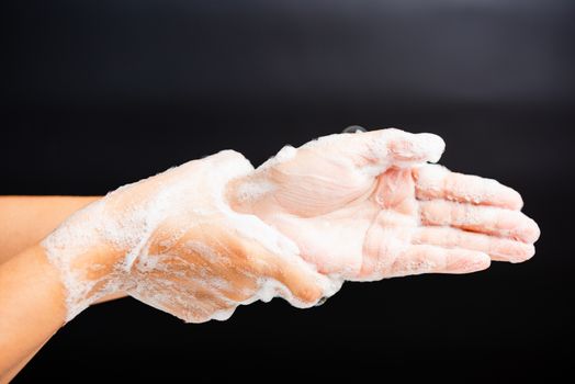 Closeup body care Asian young woman washing hands with soap have foam, hygiene prevention COVID-19 or coronavirus protection concept, isolated on black background