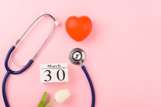 Doctor's Day concept, flat lay top view, equipment medical red heart and stethoscope on pink background, care patient in hospital with copy space for text