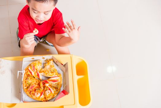 Hot Homemade, Vegetarian fast Italian food, Top view of Cute Little Child enjoying eating Delivery Pizza pepperoni, cheese many slices deliciously in a cardboard box at home with copy space for text
